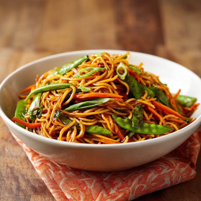 Asiatische Wok-Nudeln mit knackigem Gemüse in einer weißen Schüssel, mit Nahaufnahme der Textur und Zutaten.