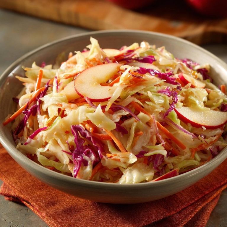 Knackiger Apfel-Krautsalat mit Apfelstücken, Rotkohl und Karotten in einer Schüssel, Nahaufnahme der Zutaten.