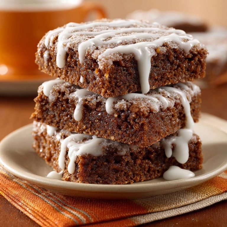 Zimtkrümel-Kuchen gestapelt mit Zuckerguss und auf einer orangen Serviette serviert.